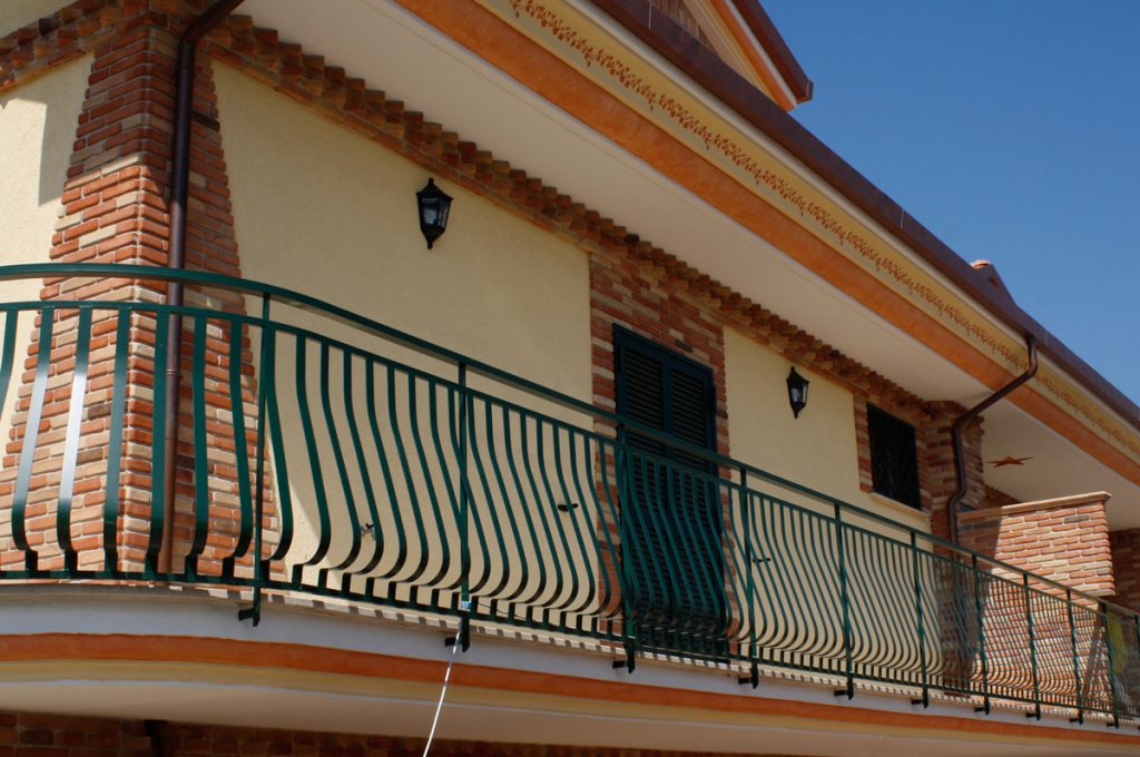Foto di una ringhiera in ferro verde per un balcone di un appartamento.